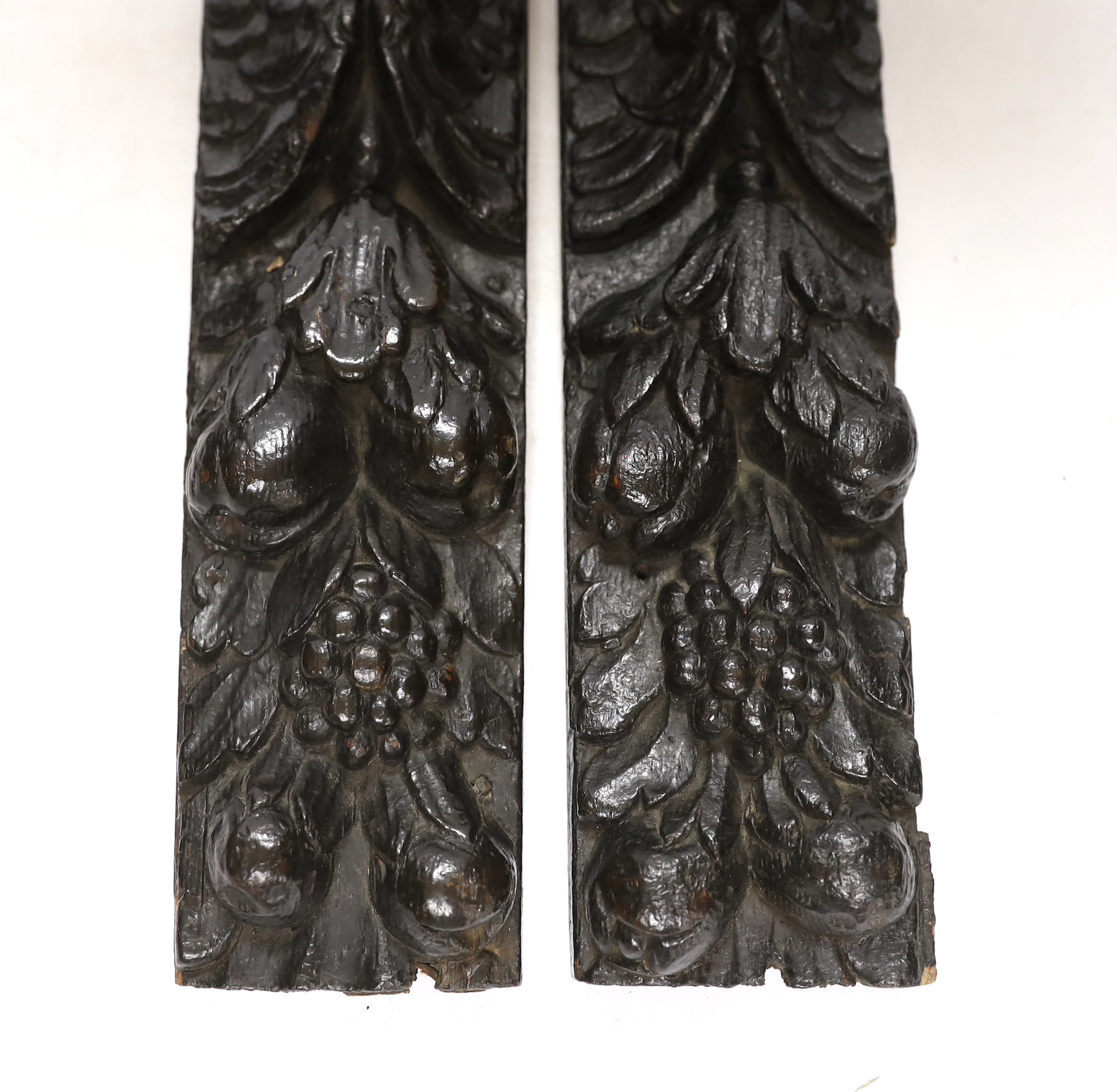 A pair of 17th century carved oak jambs, carved with putti decoration, 39cm